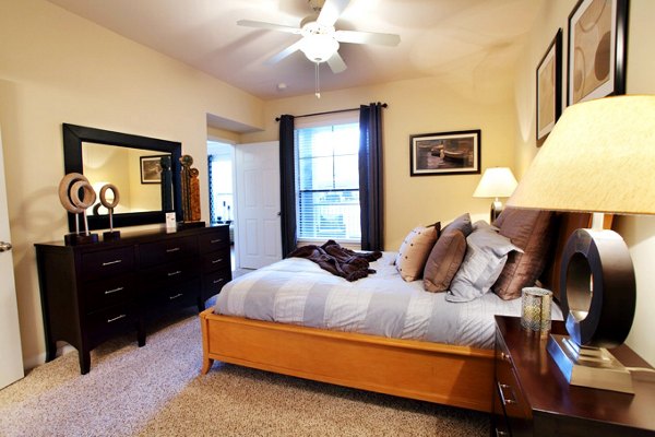 Bedroom with modern decor and plush bedding at West End Apartments