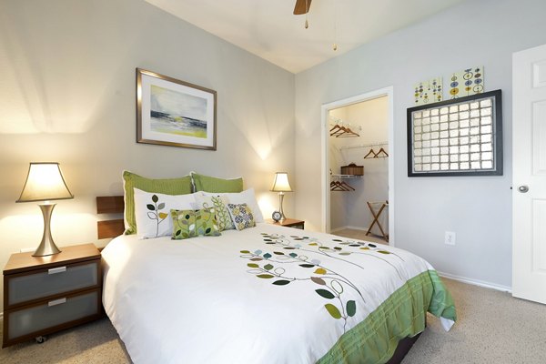 Cozy bedroom with modern decor and ample natural light at Terrazzo Apartments