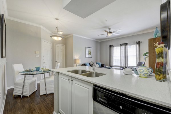 Modern kitchen with stainless steel appliances at Terrazzo Apartments featuring sleek cabinetry and granite countertops