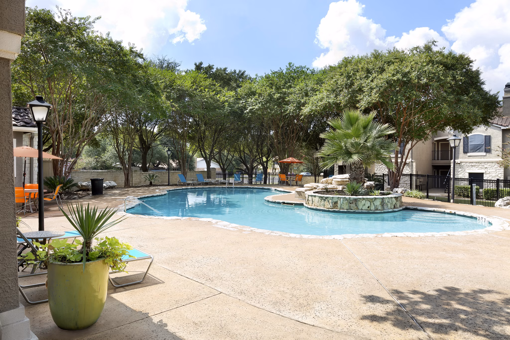 Resort-style swimming pool with lounge seating at Terrazzo Apartments, luxury living in a vibrant community