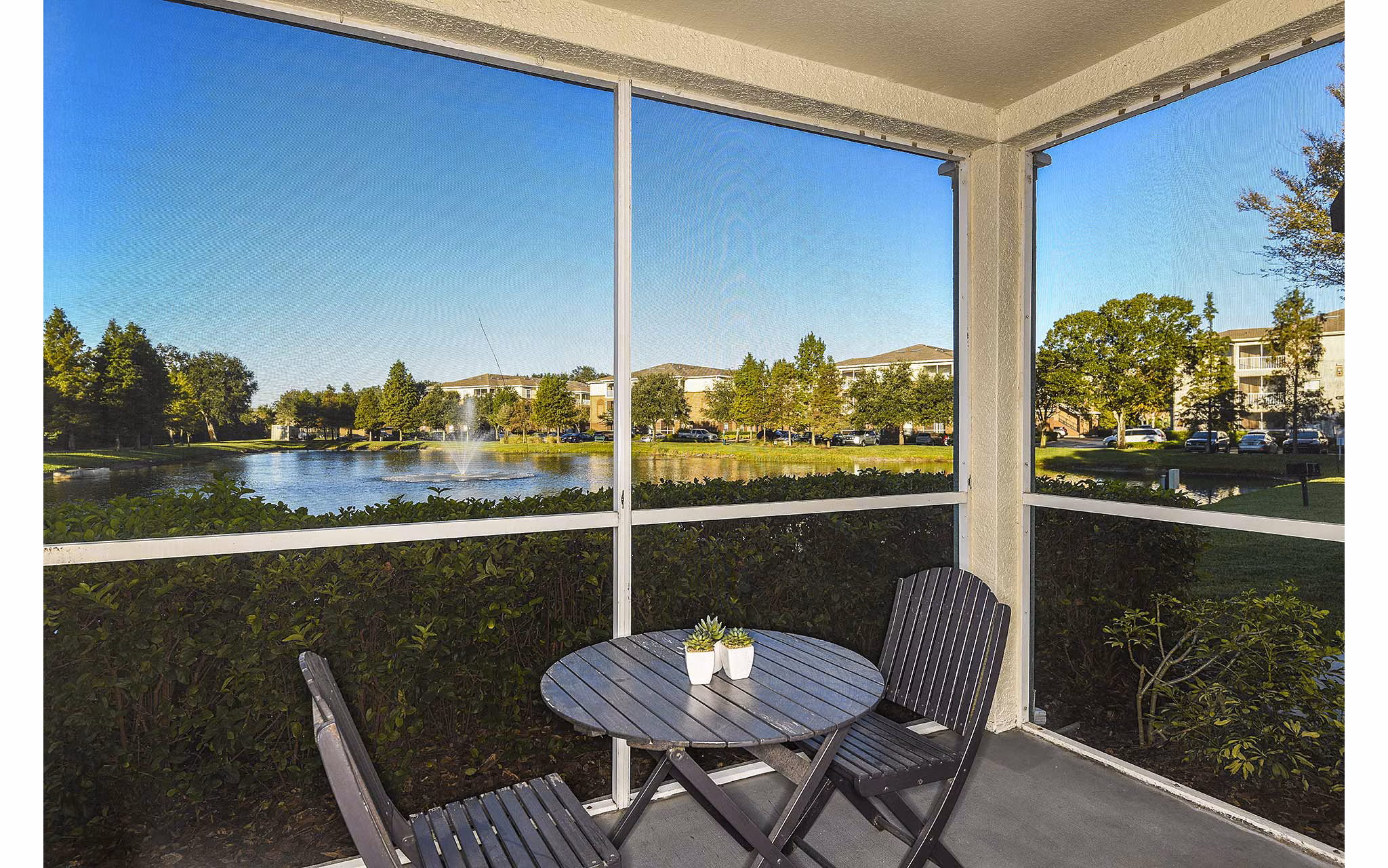Private patio at Villas at Gateway Apartments featuring comfortable seating and overlooking lush gardens