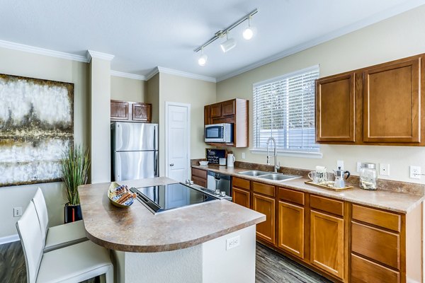 Kitchen featuring modern appliances and granite countertops at Waterford Lone Tree Apartments