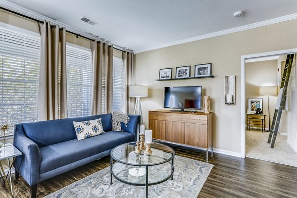 Modern living room with plush seating and large windows at Waterford Lone Tree Apartments, offering luxury and comfort