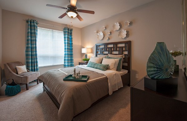 Chic bedroom with modern decor and natural light at Monaco at Main Apartments
