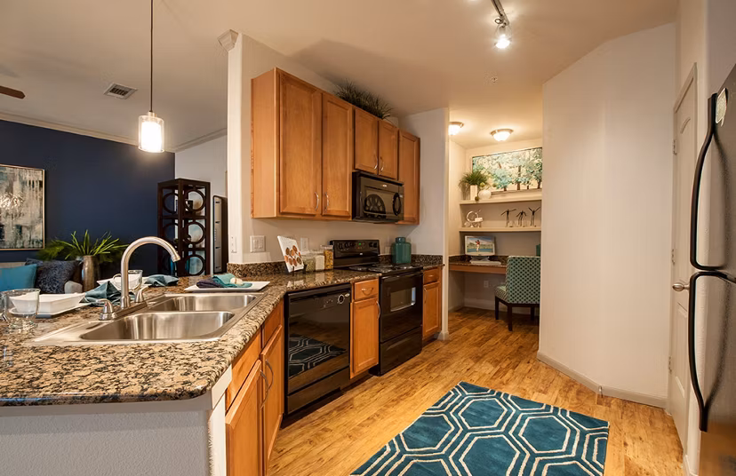 Modern kitchen with sleek countertops and stainless steel appliances at Monaco at Main Apartments