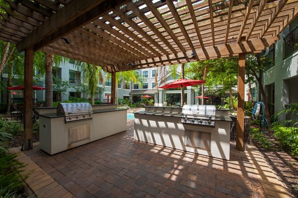 Outdoor grill area with stainless steel appliances at Monaco at Main Apartments, ideal for summer gatherings and barbecues