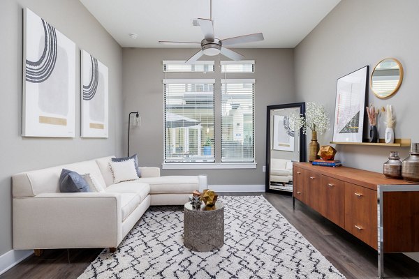 Spacious living room with modern decor and natural light in Haus 5350 Apartments