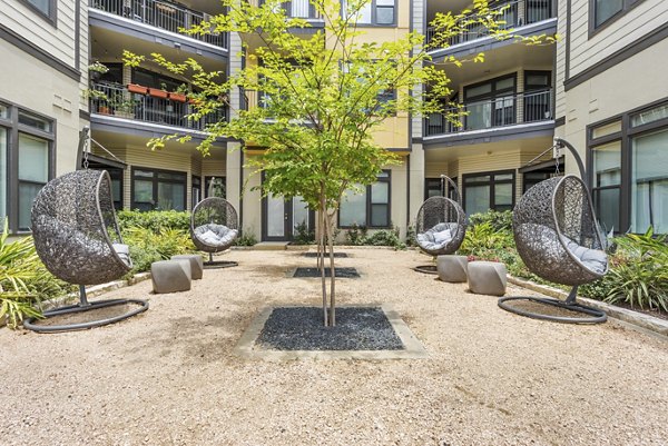 Charming courtyard with lush greenery at Milano Apartments, offering a serene outdoor space for relaxation and leisure