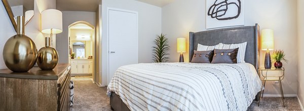 Sleek bedroom with modern furnishings and ample natural light at OTTAVO Apartments