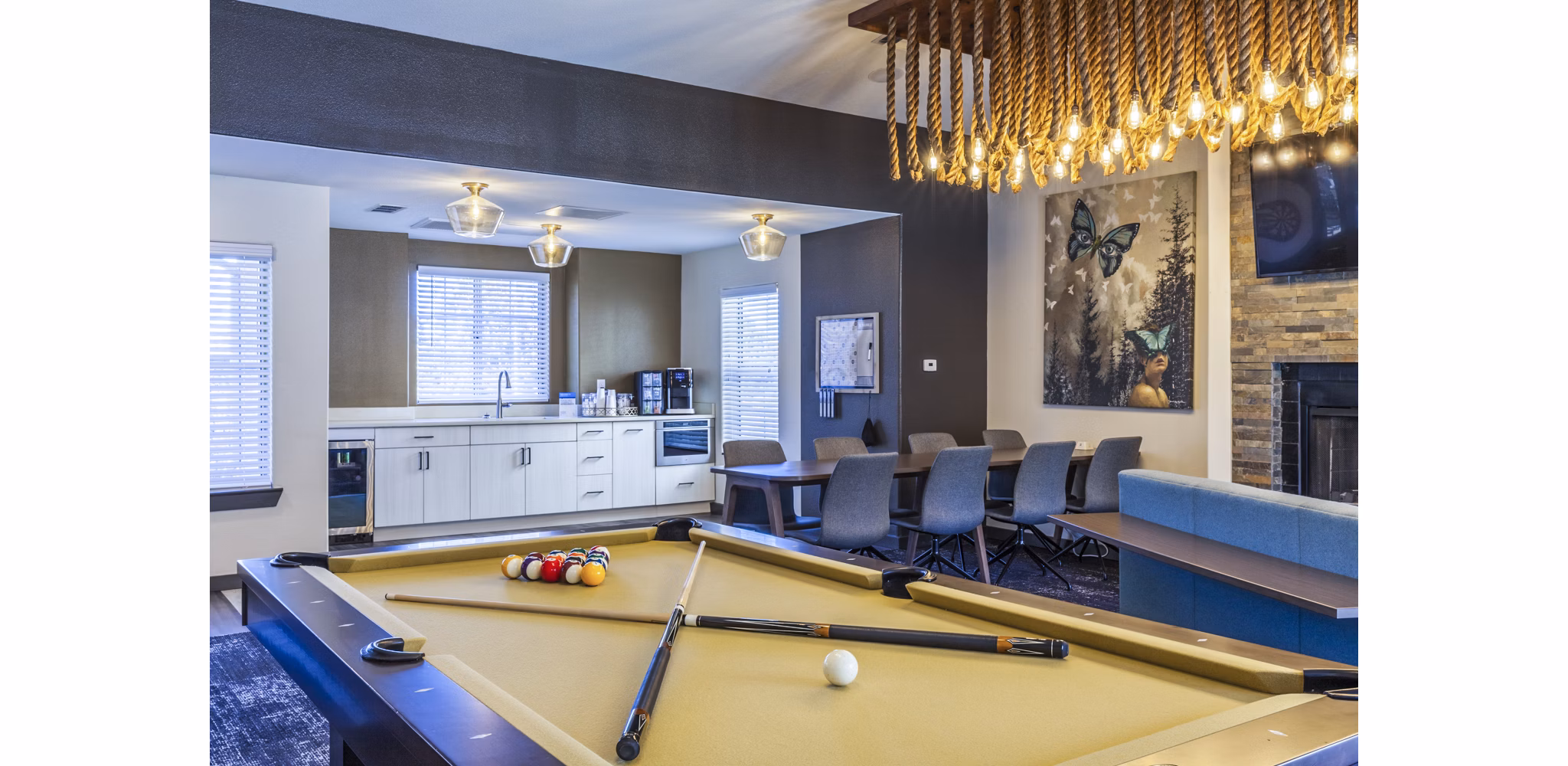 Clubhouse game room with pool table and lounge seating in OTTAVO Apartments offering luxury living