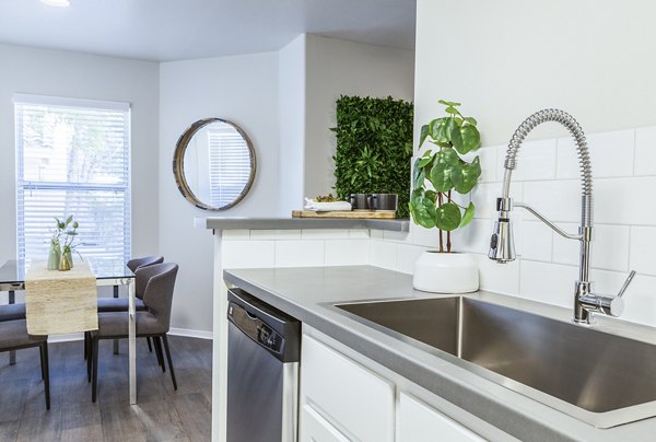 Contemporary kitchen with stainless steel appliances and marble countertops at OTTAVO Apartments