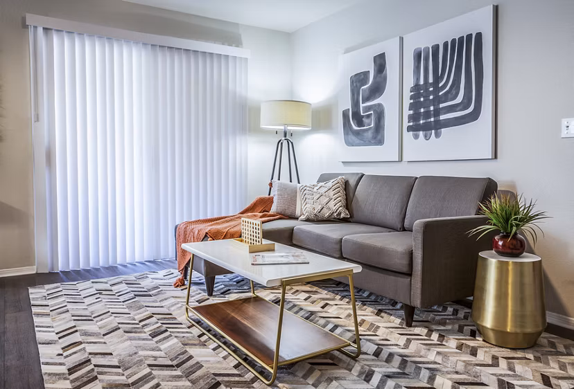 Spacious living room with modern decor and large windows in OTTAVO Apartments