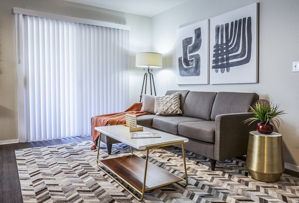 Spacious living room with modern decor and large windows in OTTAVO Apartments