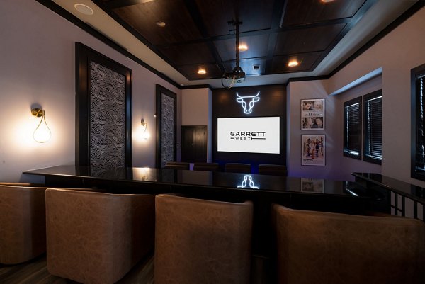 Theater room featuring plush seating and large screen at Garrett West Apartments