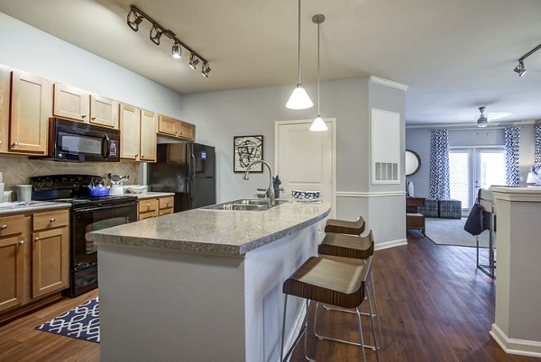 Kitchens featuring modern appliances and granite countertops at Garrett West Apartments