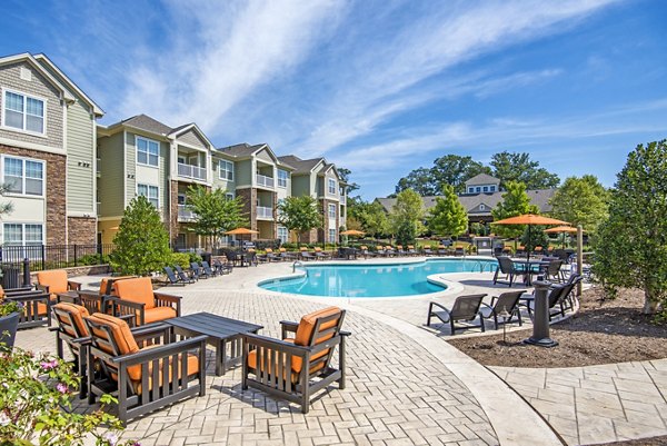 Resort-style pool area with sun loungers at Garrett West Apartments, a luxury living community