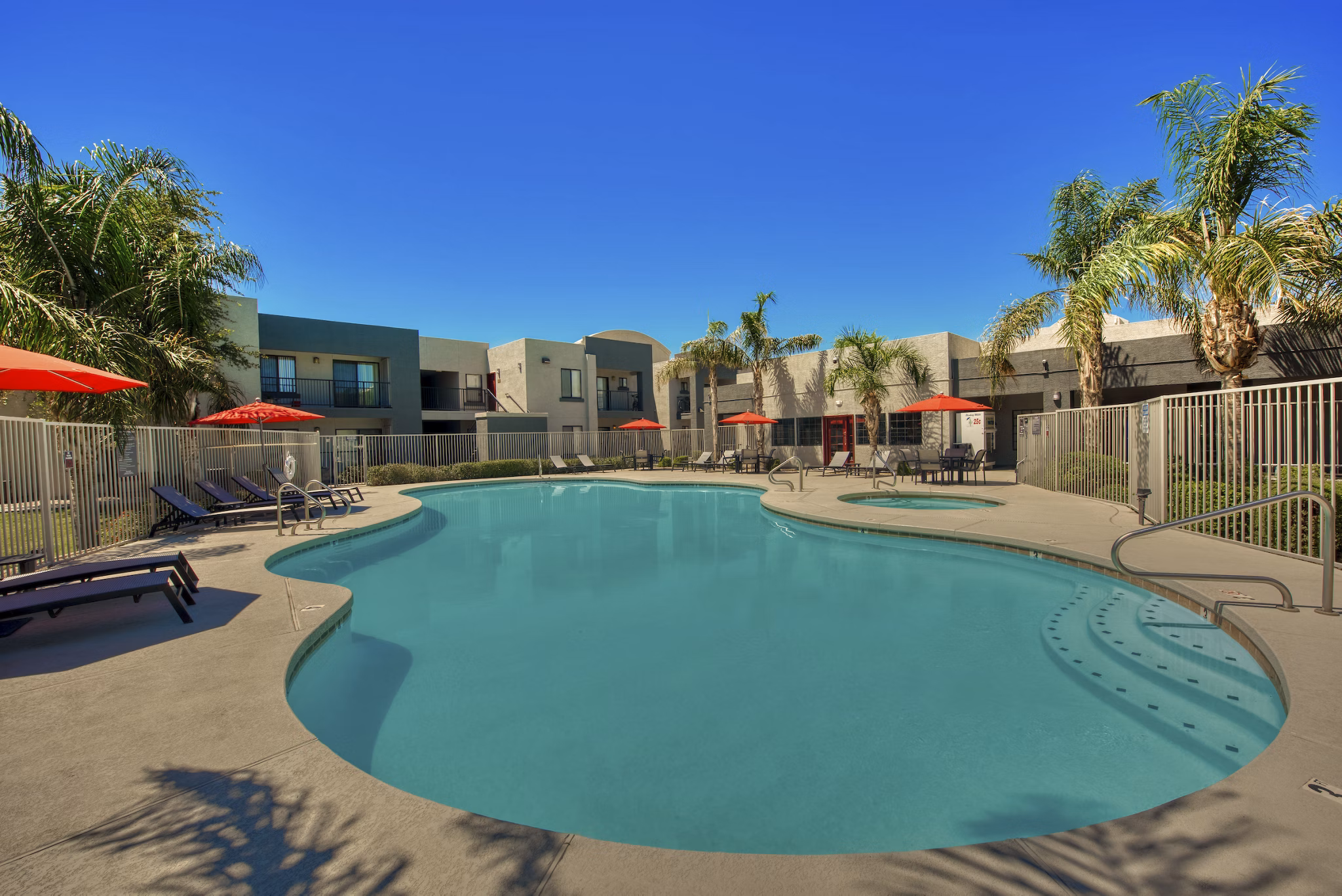 Relaxing pool area with lounge chairs at Esteban Park Apartments, a Greystar luxury community