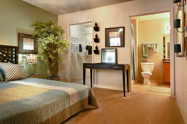 Modern bedroom with elegant decor at Esteban Park Apartments featuring luxurious bedding and ample natural light