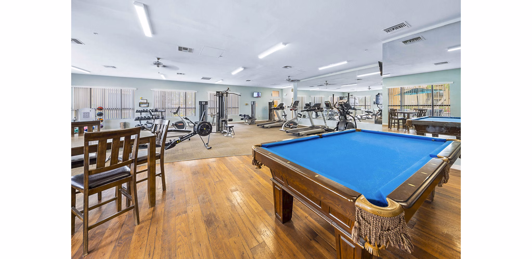 Modern fitness center and clubhouse game room at The Colony Apartments offering luxury amenities