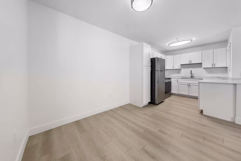 Cozy living room with modern furnishings and large windows at The Colony Apartments