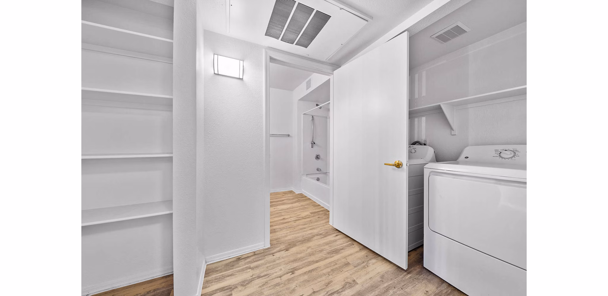 Laundry room with modern appliances at The Colony Apartments