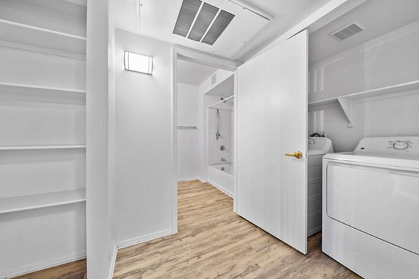 Laundry room with modern appliances at The Colony Apartments