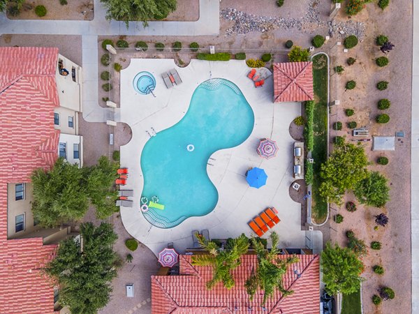 Serene outdoor pool with lounge seating at The Colony Apartments, a Greystar luxury community