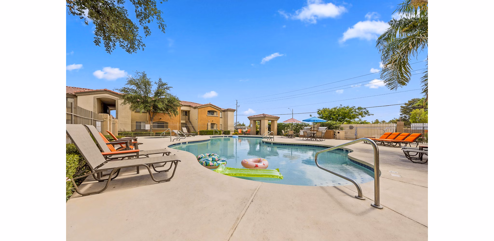 Relaxing outdoor pool area at The Colony Apartments with lounge seating