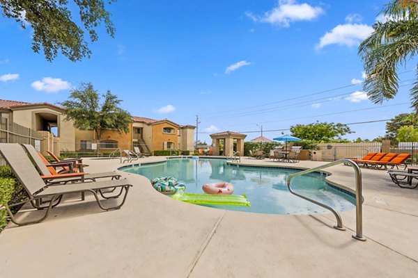 Relaxing outdoor pool area at The Colony Apartments with lounge seating