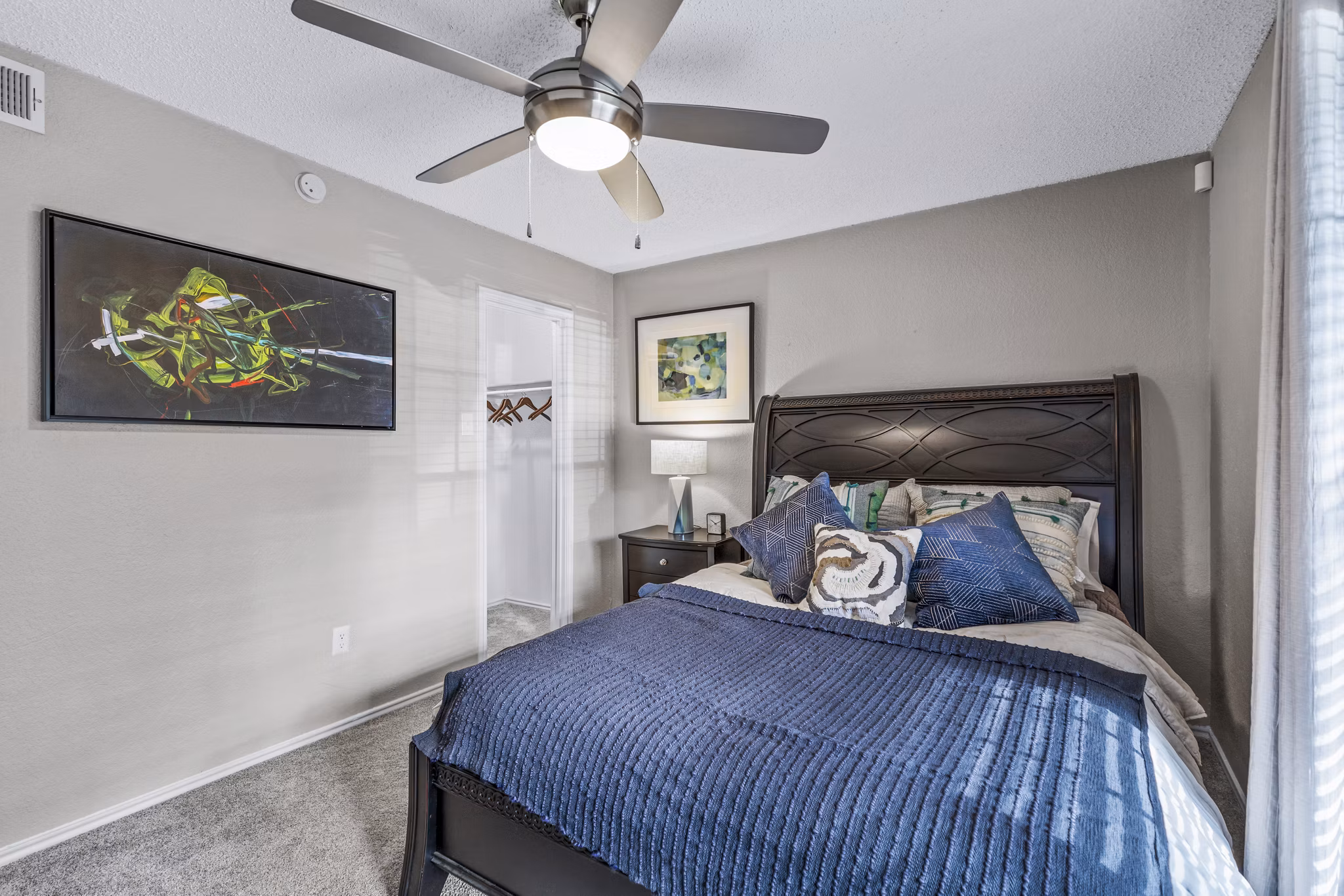 Bedroom with modern furnishings and large windows at The Georgian Apartments, offering luxury living spaces in a premier location