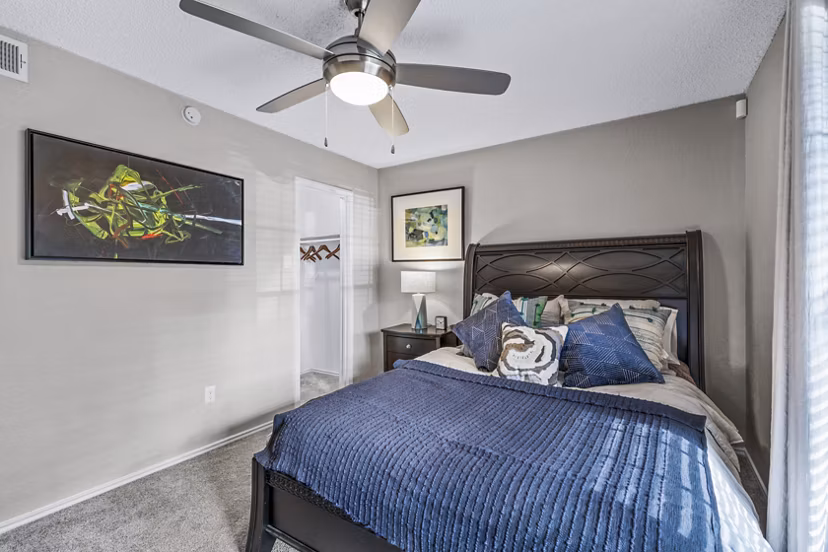 Bedroom with modern furnishings and large windows at The Georgian Apartments, offering luxury living spaces in a premier location