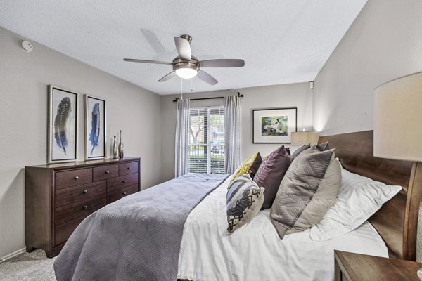 Bedroom with elegant decor and large windows in The Georgian Apartments, a luxury property by Greystar in an upscale neighborhood