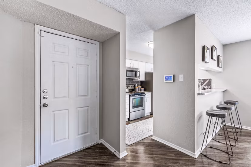 Entrance leading to a modern kitchen at The Georgian Apartments featuring sleek cabinetry and stainless steel appliances