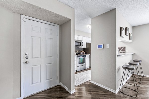 Entrance leading to a modern kitchen at The Georgian Apartments featuring sleek cabinetry and stainless steel appliances
