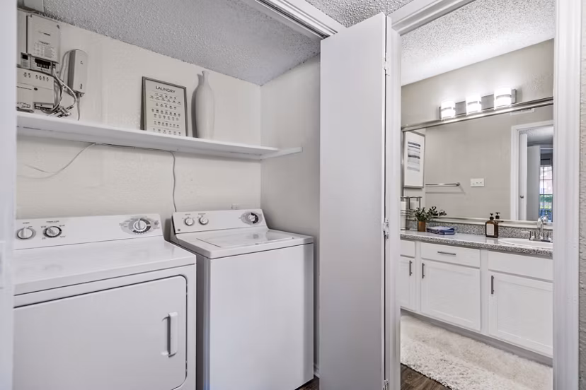 Laundry room with modern washers and dryers in The Georgian Apartments, offering luxurious convenience and style for residents