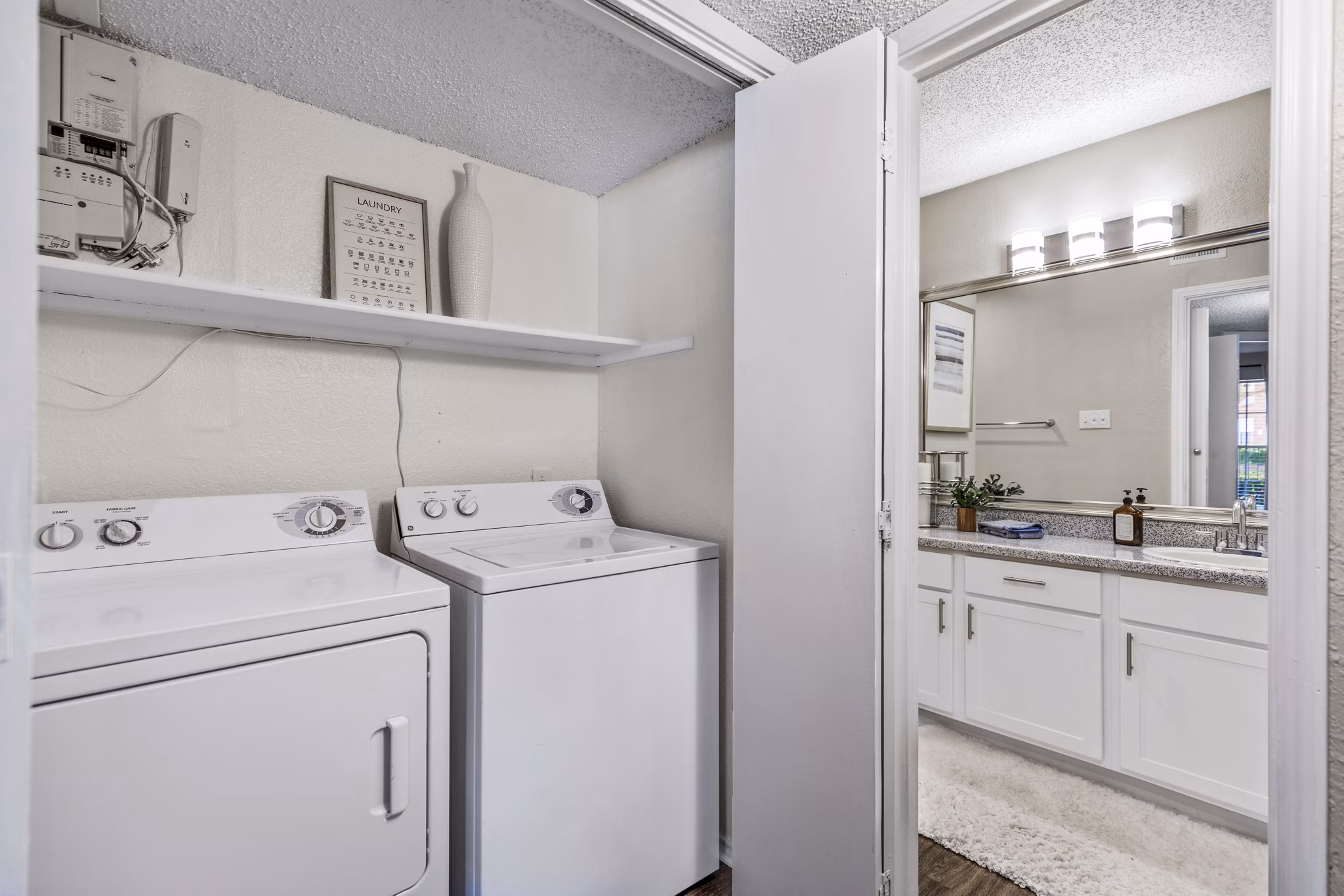 Laundry room with modern washers and dryers in The Georgian Apartments, offering luxurious convenience and style for residents