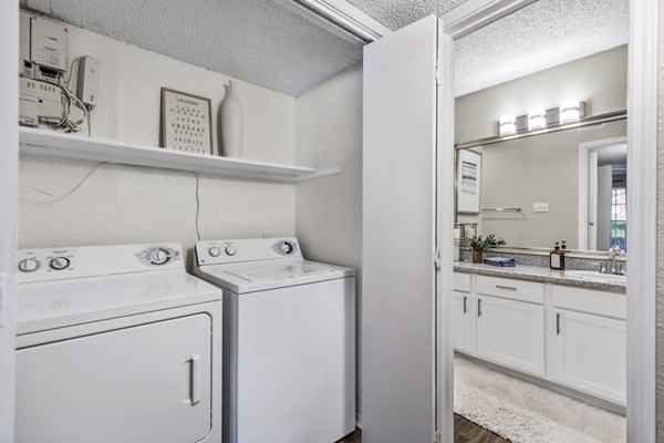 Laundry room with modern washers and dryers in The Georgian Apartments, offering luxurious convenience and style for residents