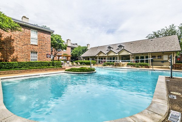 Resort-style pool surrounded by palm trees at The Georgian Apartments, a Greystar luxury community