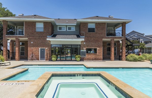 Resort-style swimming pool with sun loungers at Regal Parc Apartments in a luxury setting