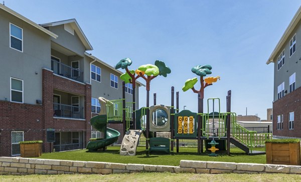 Children's playground with colorful slides and swings at Regal Parc Apartments offering family-friendly amenities