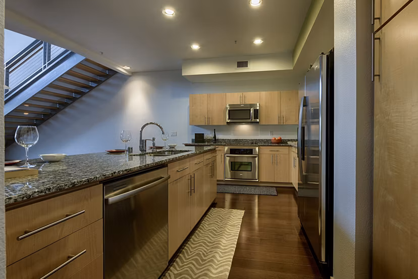Modern kitchen with stainless steel appliances in Ten Wine Lofts Apartments