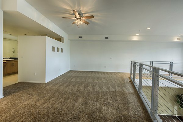 Modern living room with cozy seating and large windows at Ten Wine Lofts Apartments