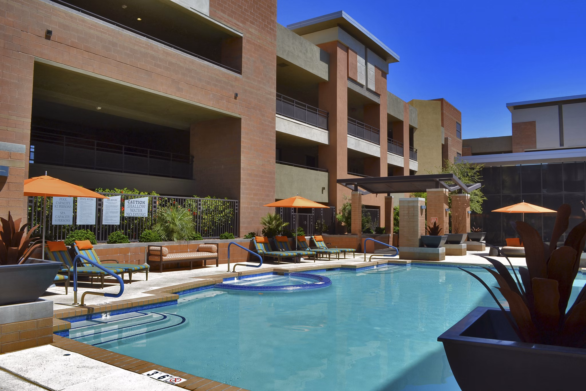 Modern pool area with loungers at Ten Wine Lofts Apartments in Scottsdale, perfect for relaxation and leisure activities