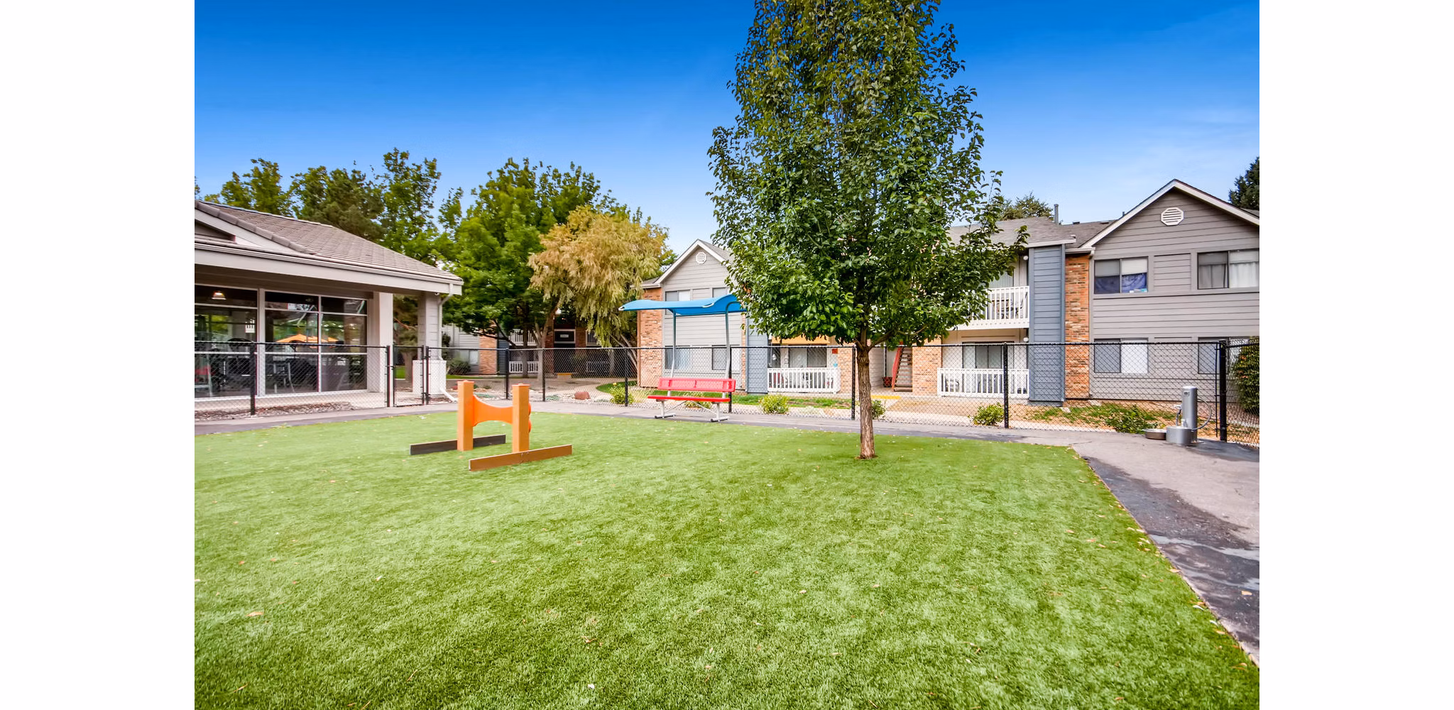 Off-leash dog park at Canyon Reserve at the Ranch Apartments, featuring agility equipment and shaded seating areas for pet owners
