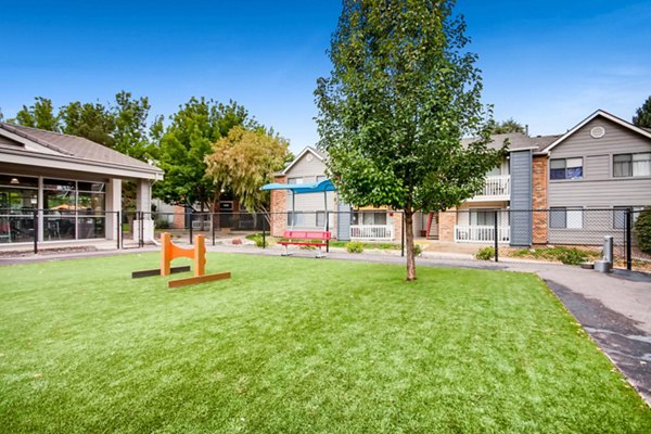 Off-leash dog park at Canyon Reserve at the Ranch Apartments, featuring agility equipment and shaded seating areas for pet owners