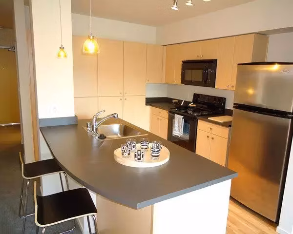 Modern kitchen with stainless steel appliances in On the Park Apartments