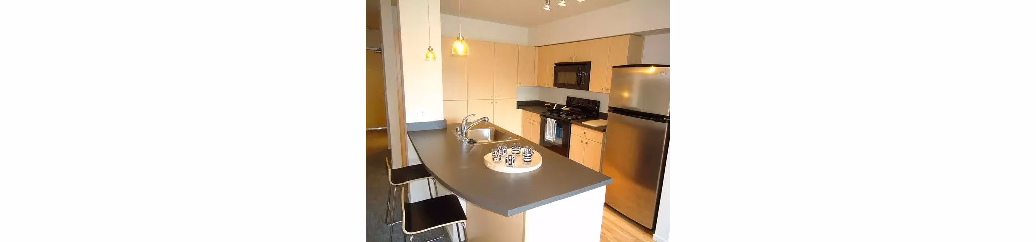 Modern kitchen with stainless steel appliances in On the Park Apartments