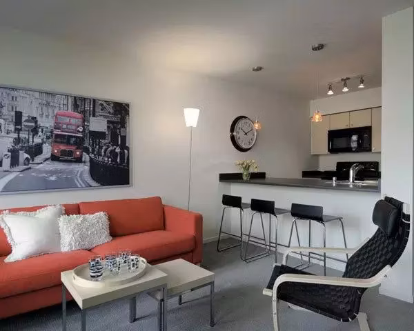 Spacious living room with modern decor and natural light at On the Park Apartments