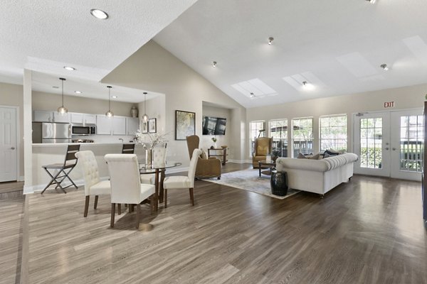 Clubhouse with modern furnishings and expansive windows at Creekwood Apartments