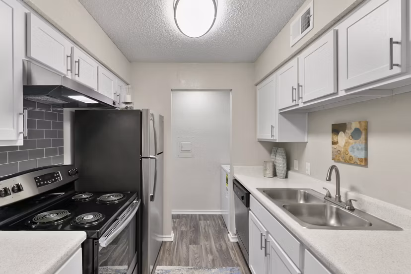 Kitchen featuring modern appliances and granite countertops at Creekwood Apartments